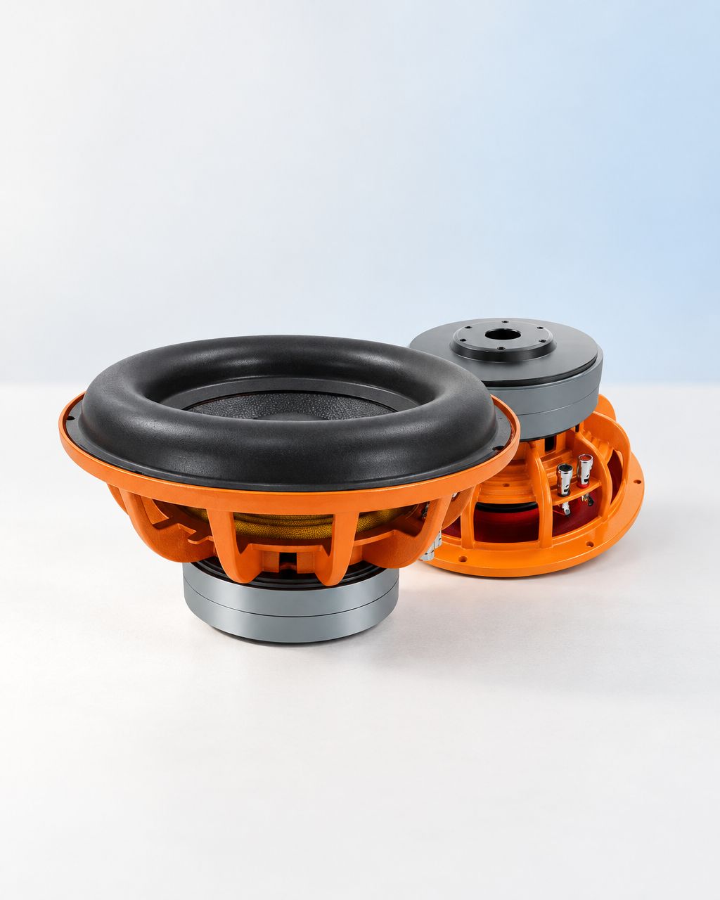 Orange-frame car subwoofer shown from front and rear on a neutral studio surface